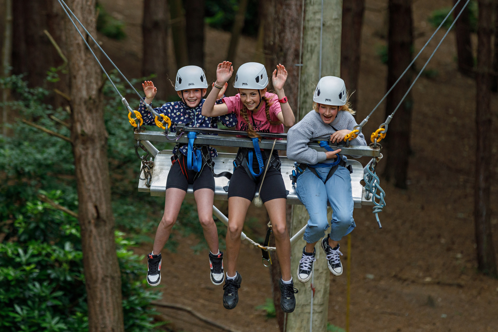 three school students on a rope swing
