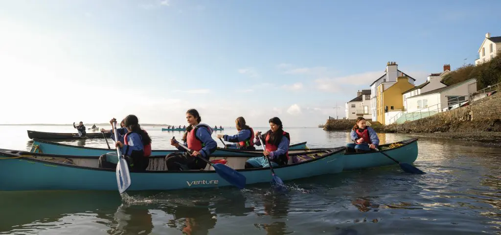 Outward Bound Aberdovey (Aberdyfi) Snowdonia Wales 6 4 teams of school pupils in three person canoes on a lake in Snowdonia Wales