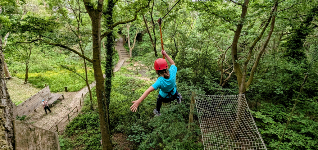 Boundless Outdoors Bell Heath Adventure Activity Centre Stourbridge 6 pupil going down a zip line in a wooded forest