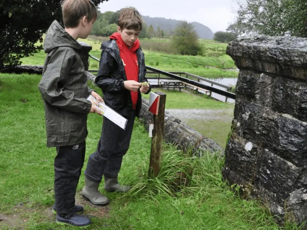 two school students outside with a map in the country