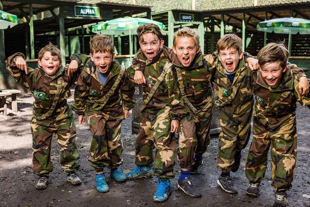 primary school pupils dressed in combat gear doing paint balling
