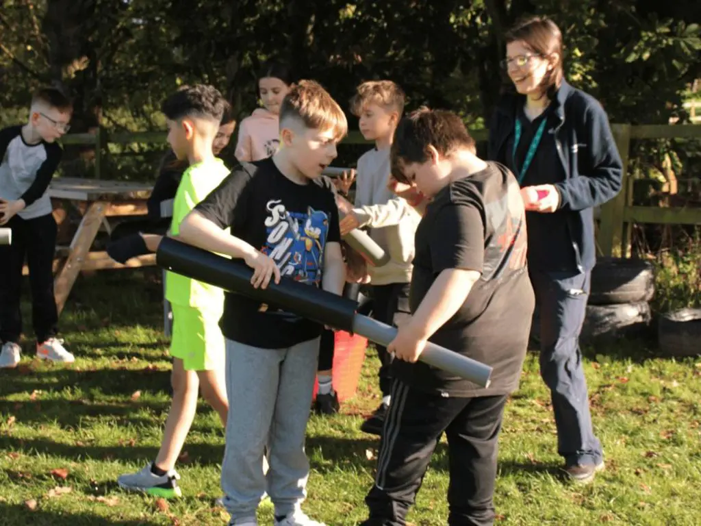 students in a field doing problem solving exercises with a teacher