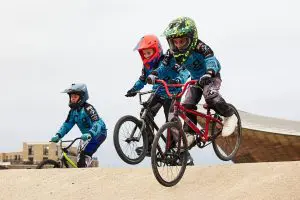 school students on BMX bikes going around a BMX track outside
