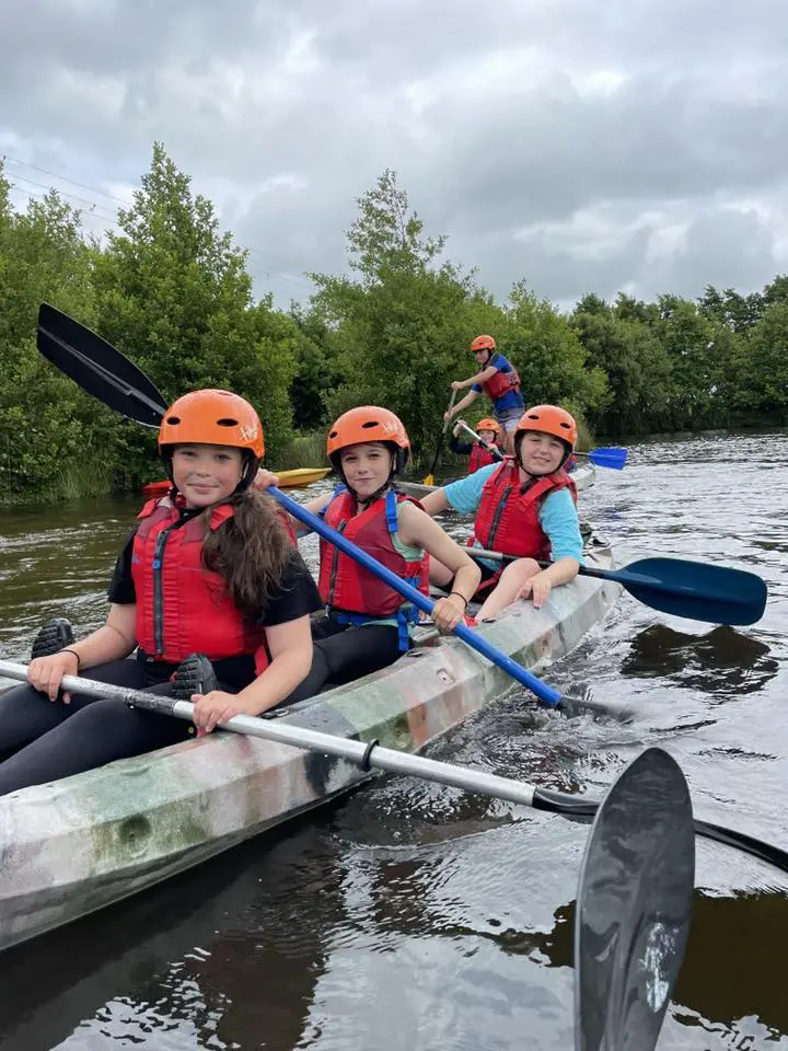 school trip students canoeing down a river