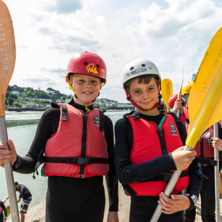two school pupils with wet suits and paddles for kayaking