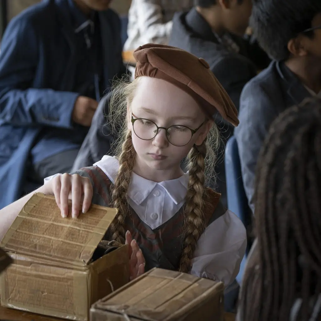 school child looking in boxes