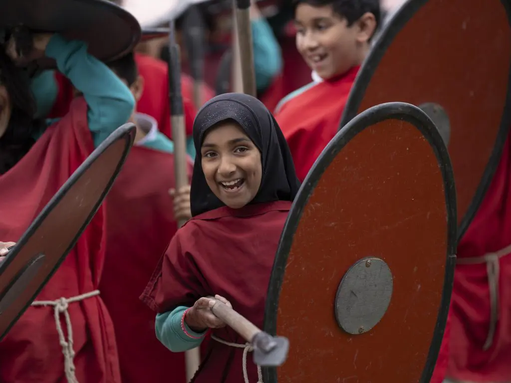 student in Celtic clothing with spear and shield
