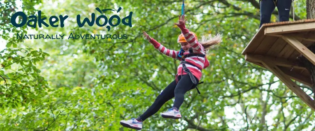 school girl going down a zip wire in a forest