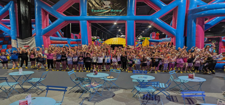 school group smiling and waving at indoor trampoline activity centre