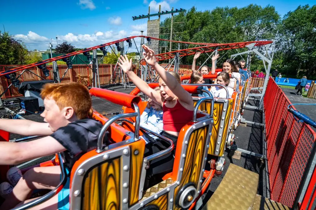 school group on a mini roller coaster at a adventure park