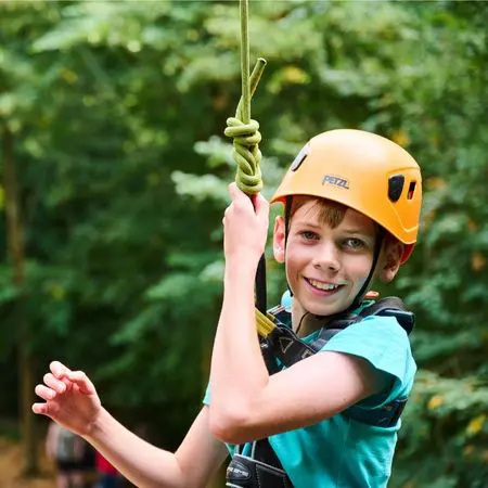 school pupil smiling with hard hat and safety rope