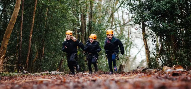 school pupils running along a forest track