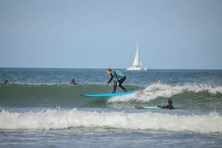 group of pupils surfing at the beach