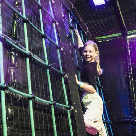 climbing cargo net with primary school pupil going up it