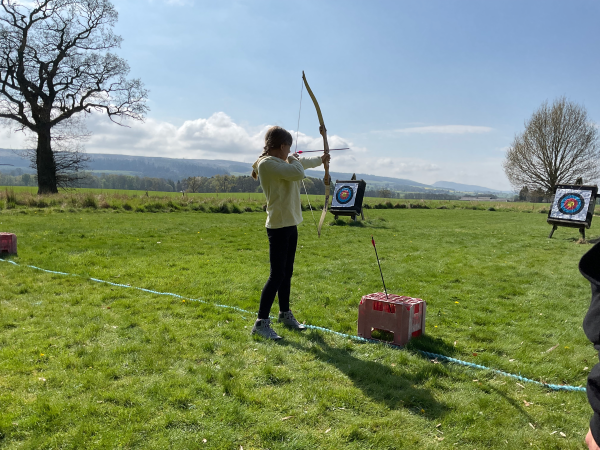 school pupil in an archery field outdoors