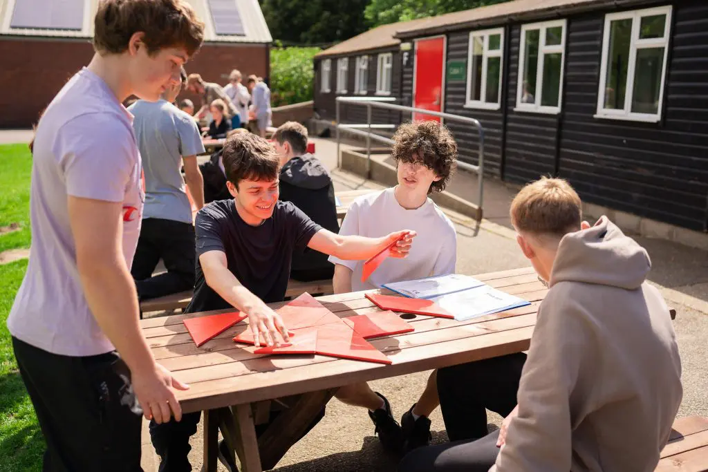group of school trip students outside completing puzzles and tasks