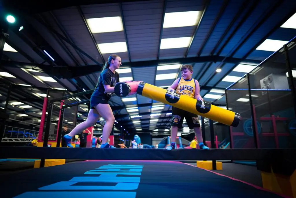 two pupils on a pole walking along it on an assault course