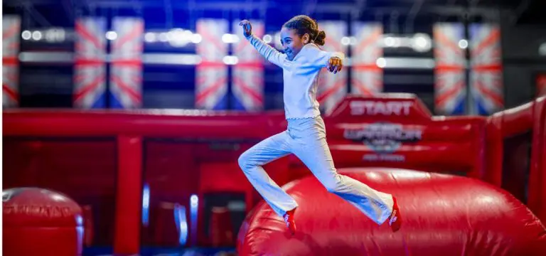 image shows school pupil jumping on indoor inflatables at Ninja Warrior Adventure Park Leeds