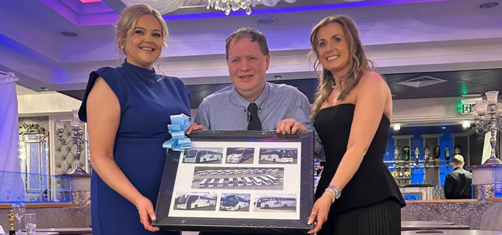 20 year anniversary presentation with owner and staff with an award for J&K coaches