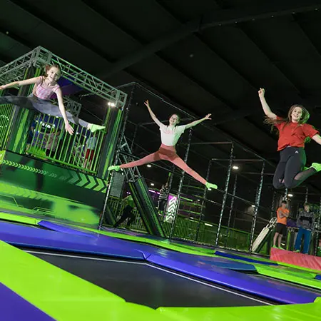 secondary school children bouncing on indoor trampolines