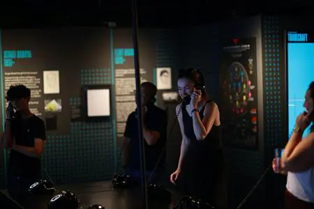 students in museum area looking at interactive activities