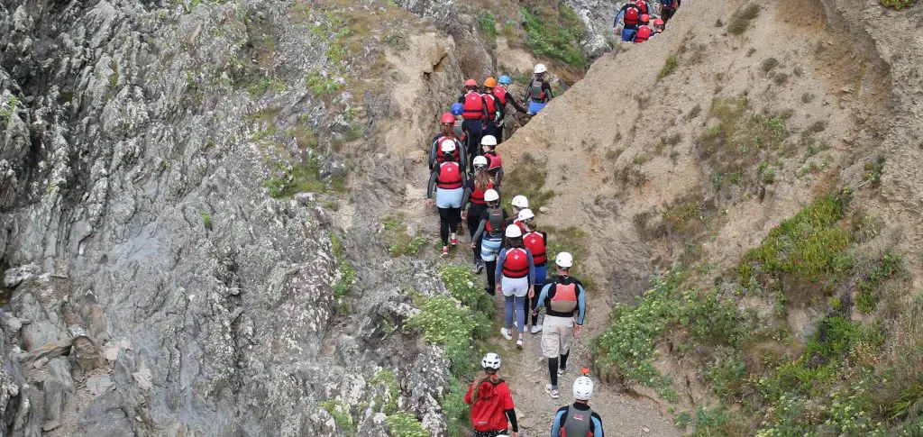 school group walking up crags at the beach