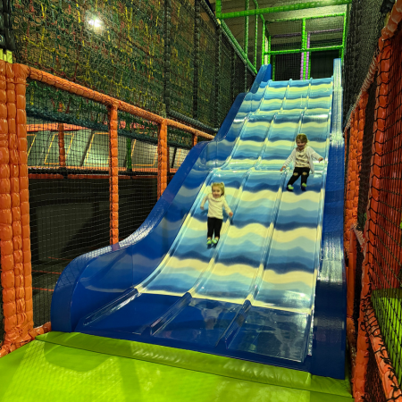 primary school pupils on an indoor slide at an activity and soft play centre