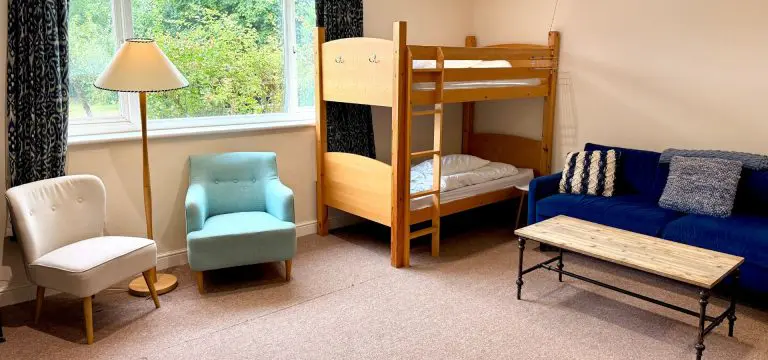 dorm room with bunkbeds chairs and a table