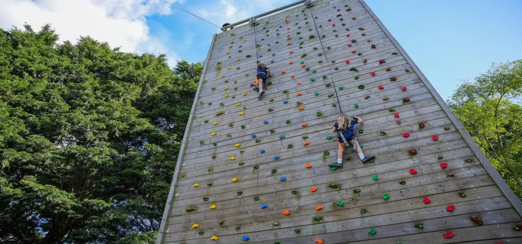 two primary pupils absailing down a climbing wall