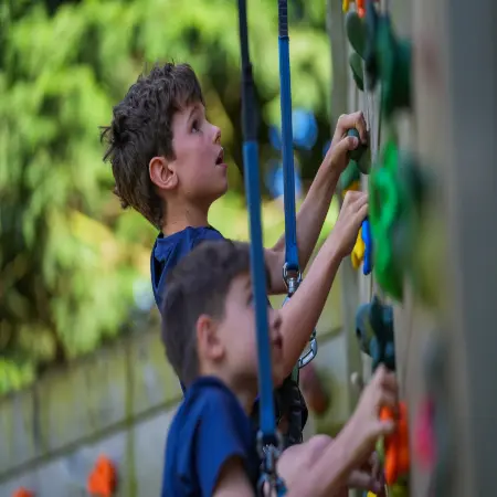 two pupils climbing up a climbing tower