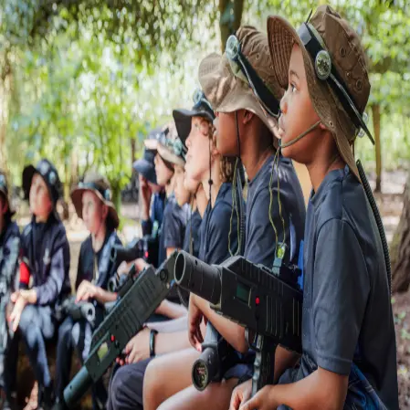 school group with laser guns and combat gear in a wooded forest