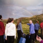 school pupils outside in Snowdonia looking a a rainbow in the sky