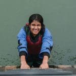 school pupil in the water with life jacket on smiling