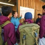 instructor with pupils in a group with hiking boots and back packs on