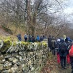 school group walking along a muddy track in a wooded area