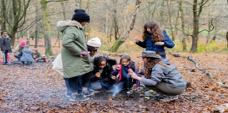 pupils in the woods starting a camp fire