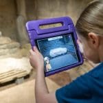school pupil looking at a tablet on an audio tour