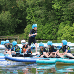 school pupils on paddle boards on a lake