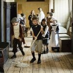 pupils dressed up in poor servant clothing in a stately home