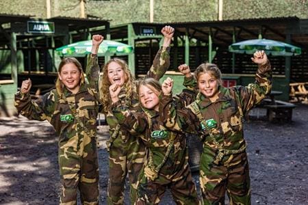 primary school pupils dressed in combat gear doing paint balling