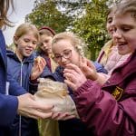 school group with replica bag of historical gold and jewels from the roman times