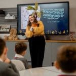 tour guide showing props of Harry Potter to pupils in a room