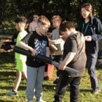 students in a field doing problem solving exercises with a teacher