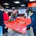 students in players home club room holding a large flag