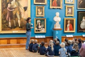 school group with museum tour person showing art work