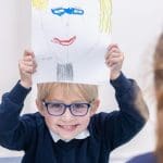 school boy with drawing of a human face
