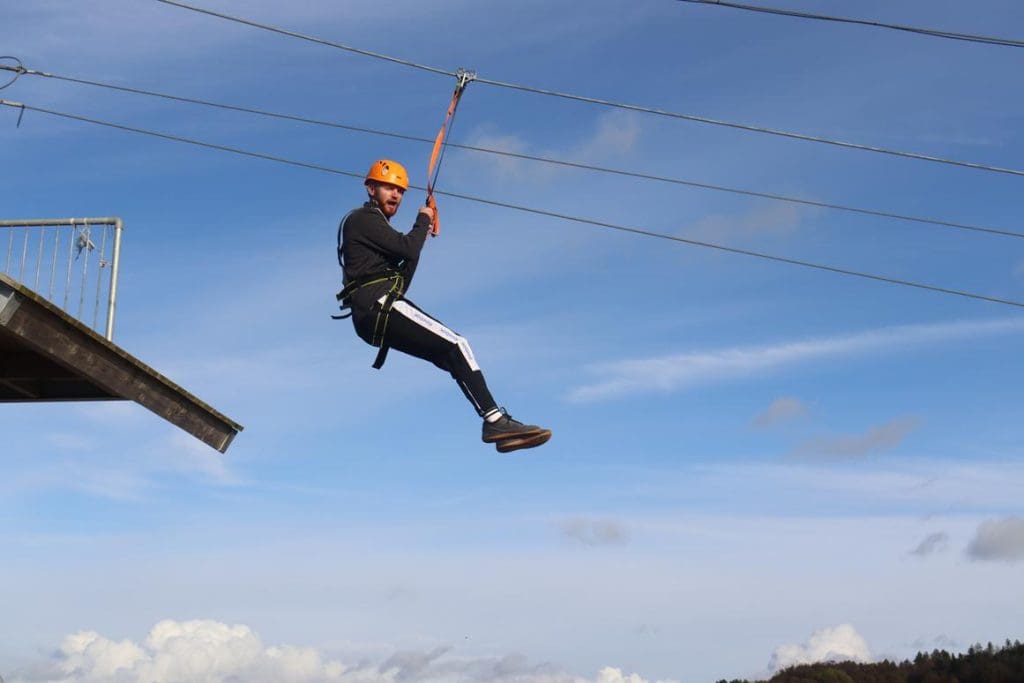 image of an instructor on a zip wire at an outdoor residential centre