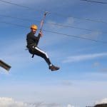 image of an instructor on a zip wire at an outdoor residential centre