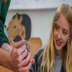 Noah’s Ark teacher holding a hedgehog with a secondary school pupil school workshop experience