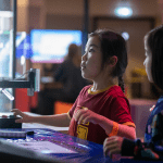 primary school pupils interacting with a machine at the Videogame Museum